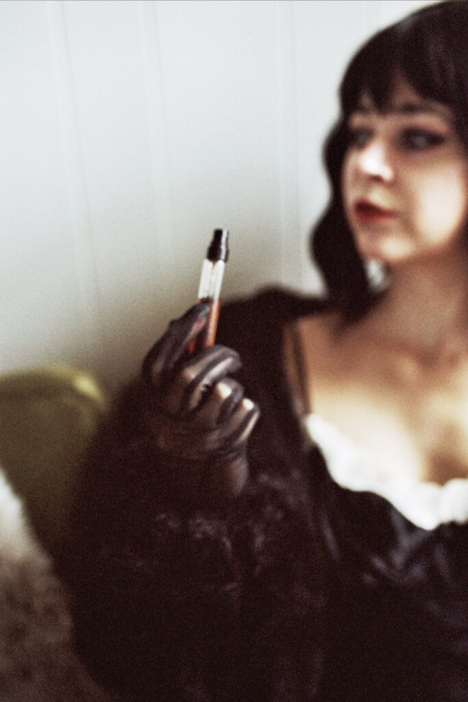 Woman with Black Hair and Vintage Playboy posing seductively for a Mob Wife Session
