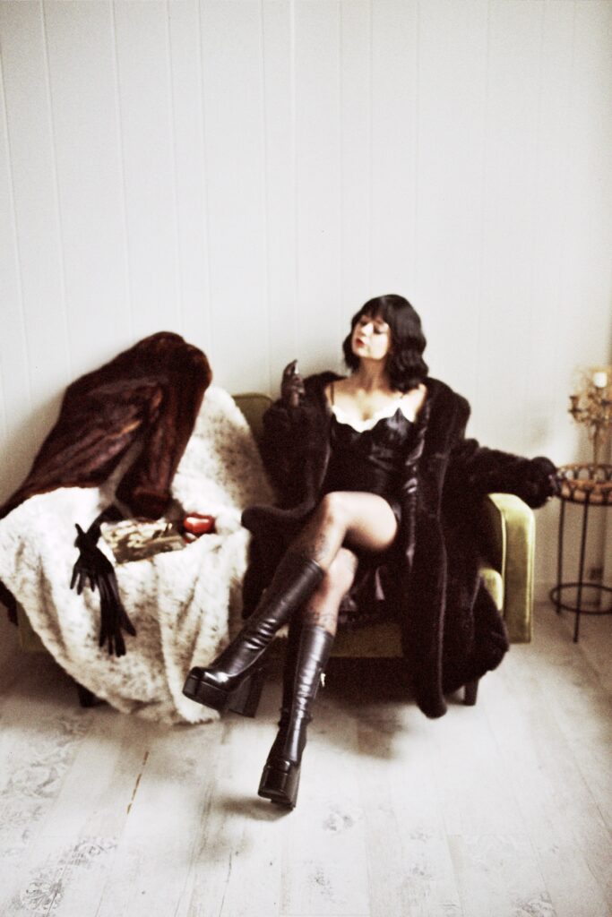 Woman with Black Hair and Vintage Playboy posing seductively for a Mob Wife Session