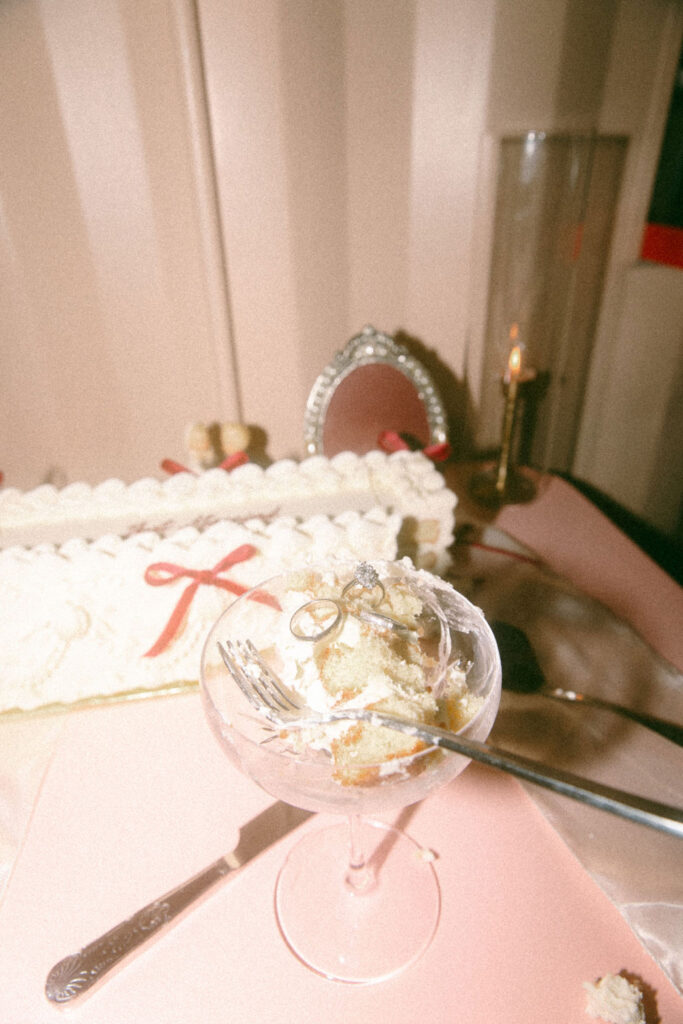 Wedding rings are photographed atop a slice of wedding cake at a Philadelphia wedding 