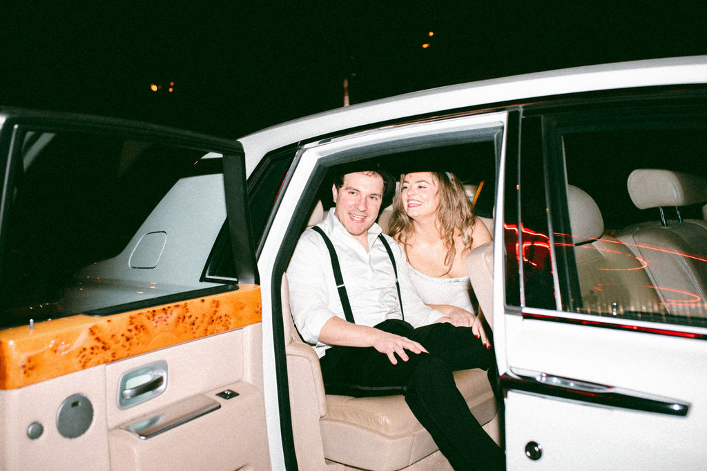 Newlyweds smile in a car following their exit from their wedding at La Chinesca Philly