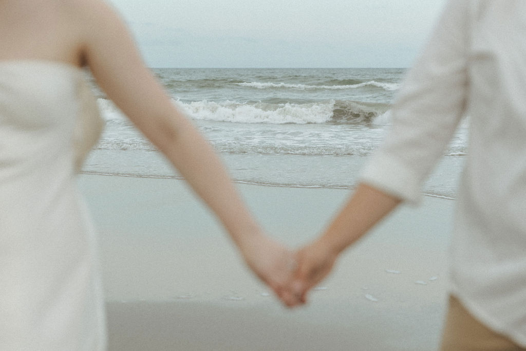 Couple holding hands on the beach