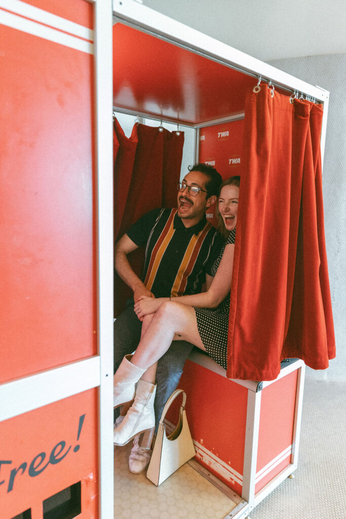 Couple doing engagement photos in a NYC photobooth