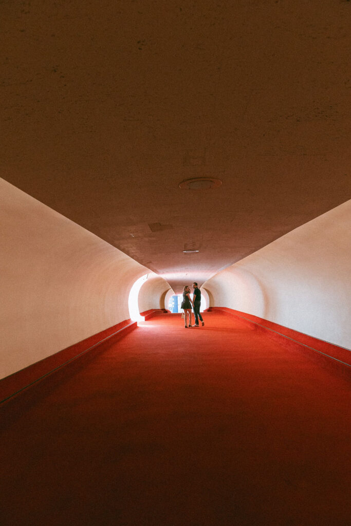 Couple running down the flight tubes in the TWA hotel