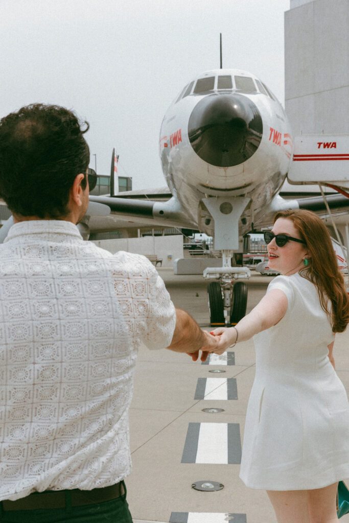 Close-up of a couple wearing vintage 1960s style sunglasses and outfits at the TWA Hotel wedding venue